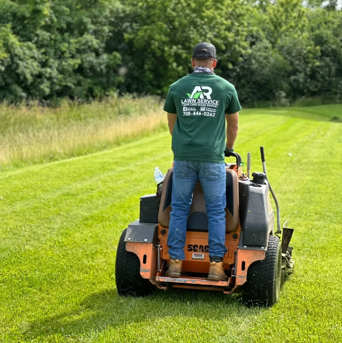 An A.R Lawn Service crew member mowing a customer property