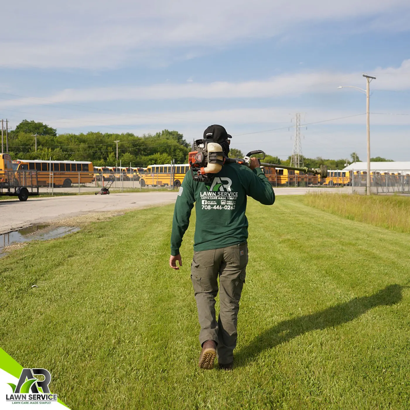 A.R Lawn Service crew member carrying professional trimming equipment