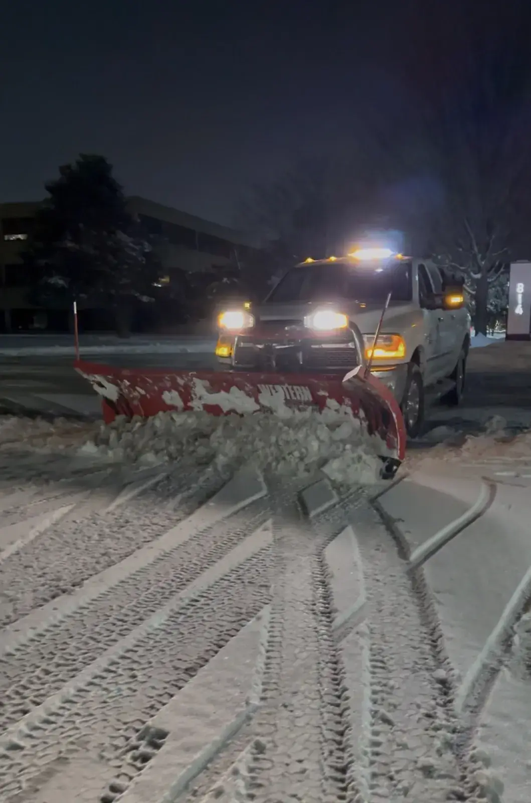 An A.R Lawn Service snowplow working at night