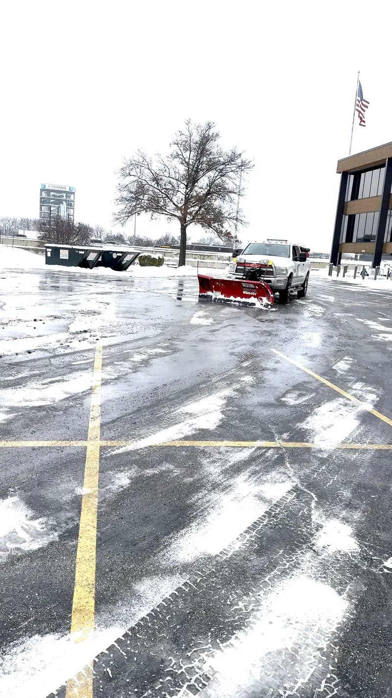 A.R Lawn Service truck with a snowplow at a commercial property in Oak Brook